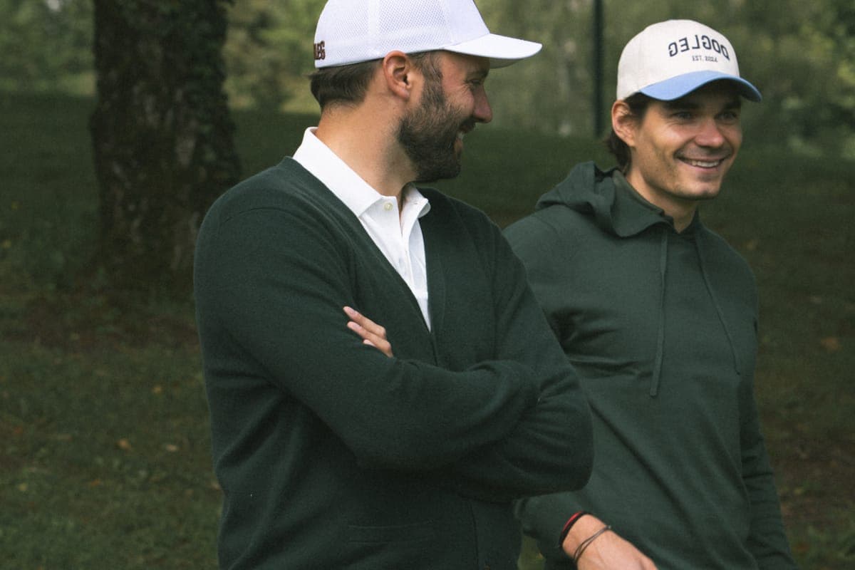 Due golfisti Dogleg in cardigan e felpa verdi sul percorso