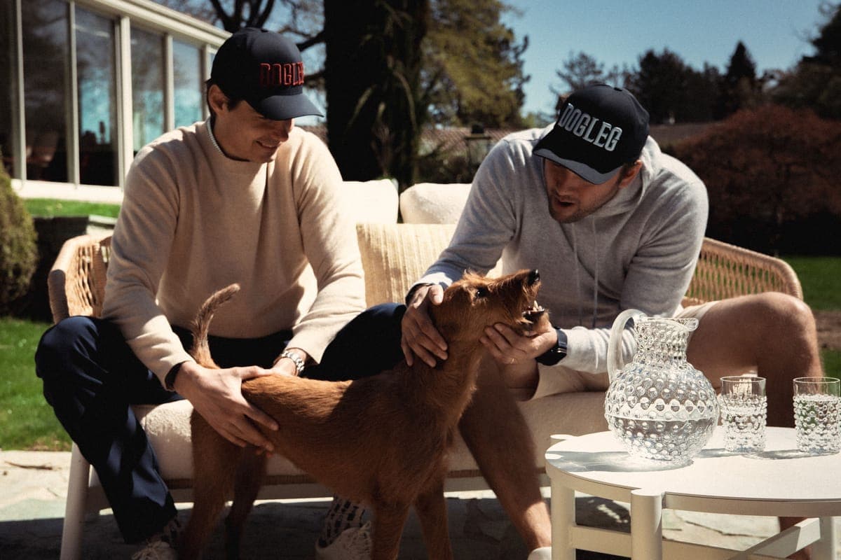 Two Dogleg founders and their dog on the terrace