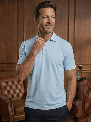 Polo de golf Dogleg Tailored bleu clair porté par un golfeur — coupe ajustée, golf Suisse